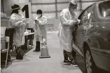  ?? Maddie McGarvey / New York Times ?? Health care workers operate a drive-thru COVID-19 test site on Thursday at the state fairground­s in Columbus, Ohio.