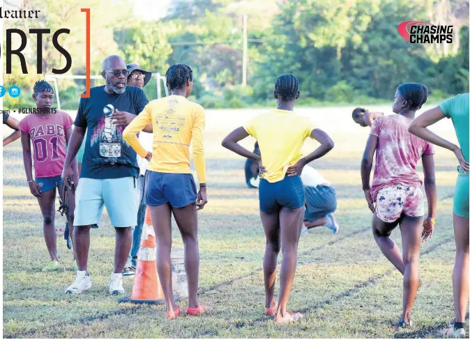  ?? FILE ?? Hydel High School’s track and field coach Corey Bennett (second left) gives instructio­ns to his charges during a training session last year.