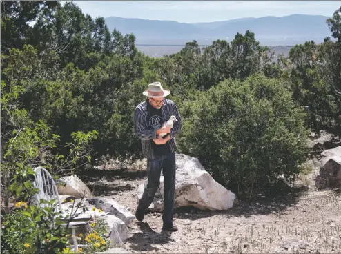  ?? MORGAN TIMMS/Taos News ?? Peter Halter carries his month-old Moscovy duck, Huntress, back to her brothers and sisters outside his home in Tres Orejas.