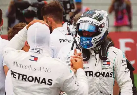 ?? REUTERS PIC ?? Mercedes driver Valtteri Bottas (right) shakes hands with teammate Lewis Hamilton after qualifying for pole position in the Austrian Grand Prix. Hamilton took second place.