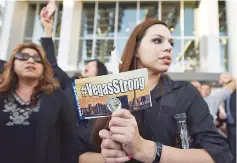  ?? — AFP photo ?? People attend a candleligh­t vigil at Las Vegas City Hall.