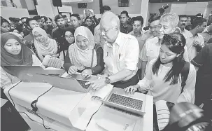  ?? — Gambar Bernama ?? RAMH MESRA: Najib beramah mesra bersama para graduan yang mendaftar Skim Latihan 1Malaysia (SL1M) Nur Natasha Zarin (tiga kanan) dan Ainur Fadzillah Zailani (kanan) selepas Majlis Perasmian Program Temu Duga Terbuka SL1M Peringkat Zon Tengah di Taman...