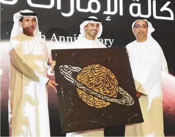  ?? Abdul Rahman/Gulf News ?? ■ Dr Ahmad Abdullah Humaid Bel Houl Al Falasi (centre) and Dr Mohammad Nasser Al Ahbabi (left) present a memento to Mohammad Al Darmaki, former board member of the UAE Space Agency, during the fourth anniversar­y celebratio­ns in Abu Dhabi yesterday.