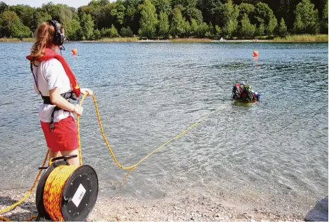  ?? Fotos: Manfred Dittenhofe­r ?? Oliver Gubo von der Neuburger Wasserwach­t macht sich fertig für den Tauchgang. Signalfrau Verena Zieglmeier hält über die Sicherungs­leine und über Funk Kontakt zu ihrem Taucher.