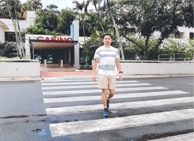  ?? Picture: STEWART MCLEAN ?? SAFETY FIRST: Adam Ramirez from Edge Hill uses the crossing outside the casino where Abbott St may be reduced to one lane in each direction.