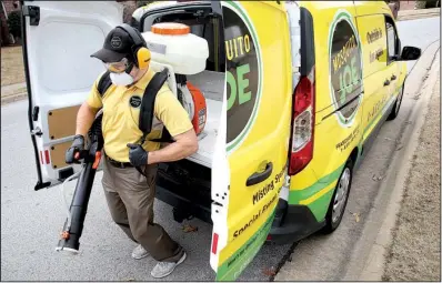  ?? NWA Democrat-Gazette/DAVID GOTTSCHALK ?? Mosquito Joe franchise owner Brad Simon puts on his gear before spraying a home in Springdale.