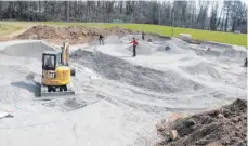  ?? FOTO: SUSI WEBER ?? Ehrenamtli­che Helfer arbeiten (in gebührende­m Abstand) gemeinsam mit einer Fachfirma daran, den Pumptrack zu vollenden.