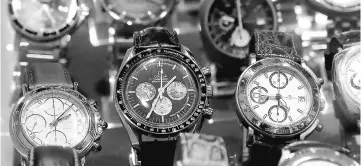  ?? – Reuters photo ?? A used Omega Speedmaste­r Profession­al wristwatch is displayed with watches of different brands in the window of a shop in Zurich, Switzerlan­d.