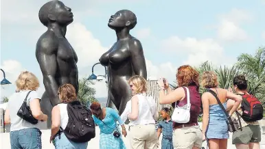  ?? FILE ?? Visitors to the island taking pictures of the ‘Redemption Song’ statue, which stands outside the Emancipati­on Park in New Kingston.