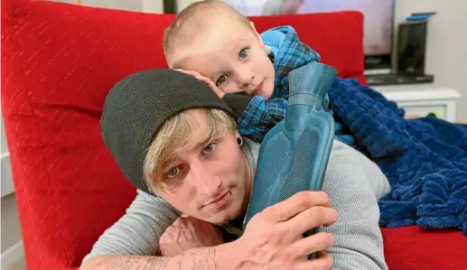  ?? PHOTO: SCOTT HAMMOND/STUFF ?? Andrew Burrow with son Matthew, 3, have been using hot water bottles and sleeping bags to keep warm.