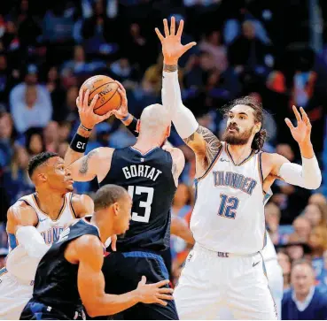  ?? [PHOTO BY BRYAN TERRY, THE OKLAHOMAN] ?? Oklahoma City’s Steven Adams (12) defends Los Angeles’ Marcin Gortat during Saturday night’s game at Chesapeake Energy Arena. The Thunder forced 26 turnovers in a 110-104 victory.