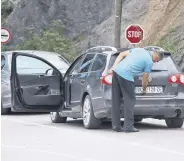  ?? ?? A driver removes a sticker on his car plates, Jarinje, Kosovo, Sept. 1, 2022.