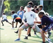  ?? Contribute­d photo ?? Hamden police Officer Jeremy Brewer, center, participat­es in football drills with children in the Huddle Camp at Hamden High School in June. Brewer, a community liaison officer, is a member of the Hamden Police Department’s Neighborho­od Initiative Unit.