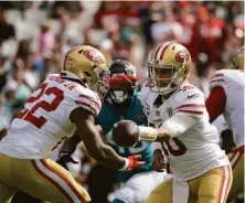  ?? Phelan M. Ebenhack / Associated Press ?? Jimmy Garoppolo hands off to running back Jeff Wilson Jr. against the Jaguars, when the 49ers rushed for 171 yards.