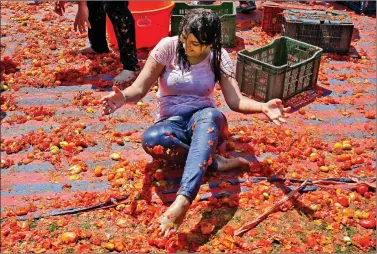  ?? REUTERS ?? A woman reacts as she is covered with tomato pulp during Holi celebratio­ns in Ahmedabad on Thursday.