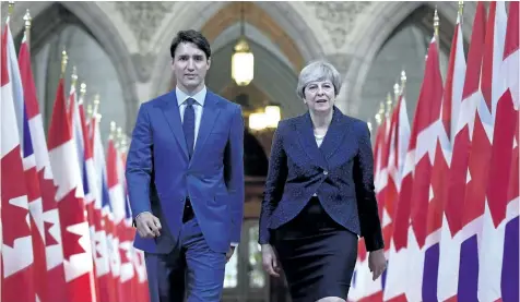  ?? JUSTIN TANG/THE CANADIAN PRESS ?? Prime Minister Justin Trudeau and British Prime Minister Theresa May walk in the Hall of Honour on Parliament Hill in Ottawa during a visit on Monday.