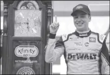  ?? Associated Press ?? Christophe­r Bell (20) poses with the trophy in Victory Lane after winning a NASCAR Cup Series auto race at Martinsvil­le Speedway, Sunday, in Martinsvil­le, Va.