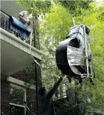  ?? MARIE-FRANCE COALLIER, GAZETTE FILES ?? Moving a piano into or out of an upper-storey dwelling is no simple task, and calls for profession­al movers who know what they’re doing.