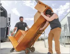  ?? OSUNA
PHOTO VINCENT ?? Humane Society of Imperial County Executive Director Devon Apodaca (left) and staff member Erik Felix move a large desk into the HSIC’s new modular building on Friday in El Centro.