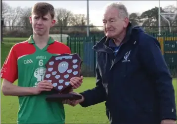  ??  ?? Eamon Doran, captain of the Gorey Community School team. accepts the shield from former Kilkenny hurling great Pat Henderson, the South Leinster Schools Servicing Officer.