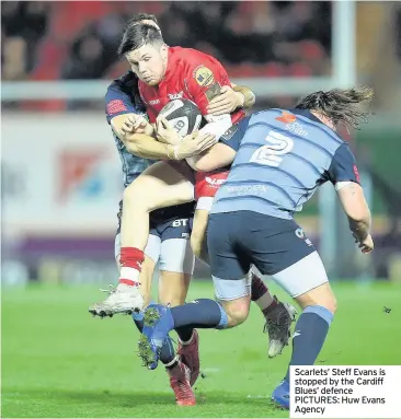  ??  ?? Scarlets’ Steff Evans is stopped by the Cardiff Blues’ defence PICTURES: Huw Evans Agency Cardiff Blues’ Nick Williams is shown a yellow card by referee Stuart Berry last night