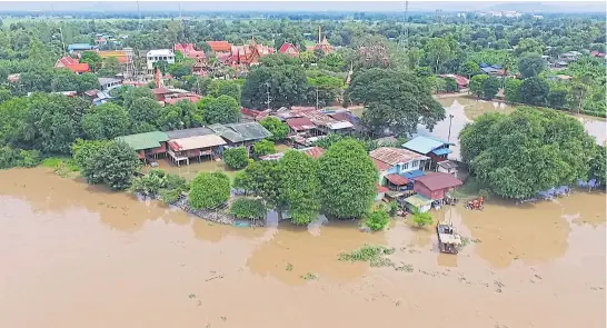  ?? CHUDET SIHAWONG ?? A community in Chai Nat’s Sapphaya district is submerged after the Chao Phraya barrage released more water to make room for additional rainfall and run-off. Local residents say the flooding caught them off guard because the authoritie­s increased the...