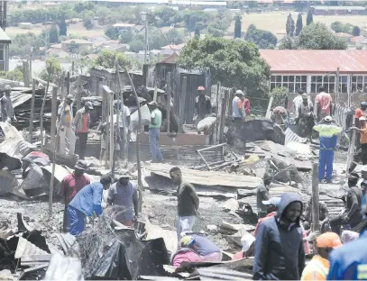  ?? Pictures: Refilwe Modise ?? MOPPING UP. Alex residents begin repairs and clean up work yesterday following a fire that ripped through the Granville informal settlement on Thursday.