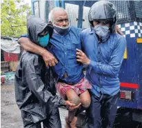  ?? REUTERS ?? Police officers carry a disabled man to a safer place following his evacuation from a slum area before Cyclone Amphan makes its landfall, in Kolkata, India on Wednesday.