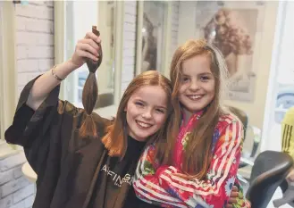  ??  ?? Isla McNicholas, with twin sister Avah after having her hair cut for the Little Princess Trust.