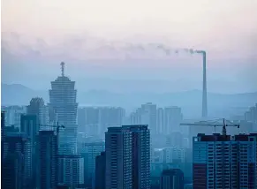  ??  ?? Dimly lit: A power station in Pyongyang in operation, as seen from its smoking chimney, but not enough energy is produced for the city. — AFP