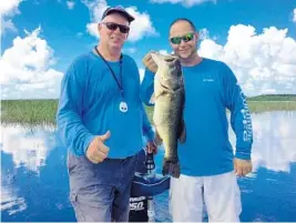  ?? STEVEWATER­S/STAFF ?? Bob Gallik, left, and his fishing partner Jeff Peterson with a 6-pound, 11-ounce bass that Peterson caught Monday on a plastic stick worm at Lake Okeechobee.