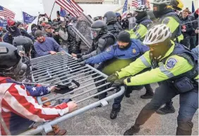  ?? JOHN MINCHILLO/AP ?? Supporters of President Donald Trump try to break through a police barrier on Jan. 6, 2021, at the U.S. Capitol.