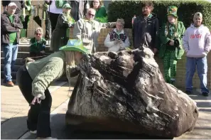  ?? The Sentinel-Record/Courtney Edwards ?? ■ A contestant in the Blarney Stone Kissing Contest takes her turn during the First Ever 20th Annual World’s Shortest St. Patrick’s Day Parade at “romancing the stone.”