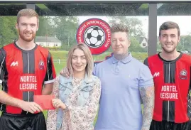  ??  ?? Support Coupar Angus Juniors players Allan Leitch (left) and Martyn McCabe present Sara and Steve Edwards with a donation for charity Harlow’s Helping Hand