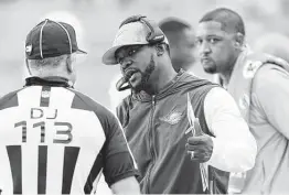  ?? Wilfredo Lee / Associated Press ?? Dolphins coach Brian Flores, center, has helped Miami win seven consecutiv­e games after a 1-7 start to put the team on the brink of a playoff berth.