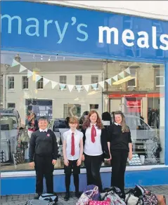  ??  ?? Some of the Kinlochlev­en High School pupils involved in the backpack project outside the Mary’s Meals shop in Oban.