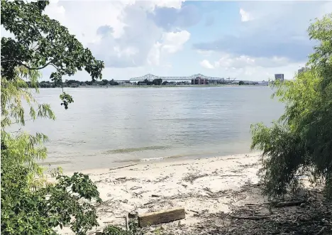  ??  ?? At Crescent Park, part of New Orleans’ riverfront developmen­t, trail users pass a sliver of beach on the Mississipp­i River.