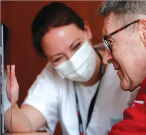  ?? — Reuters ?? Health worker Emilie Neumann helps a 79-year-old resident to attend an online video call with his relatives in France.