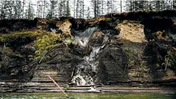  ?? MICHAEL ROBINSON CHAVEZ/THE WASHINGTON POST ?? Permafrost, at the top of the cliff, melts into the Kolyma River outside Zyryanka, Russia.