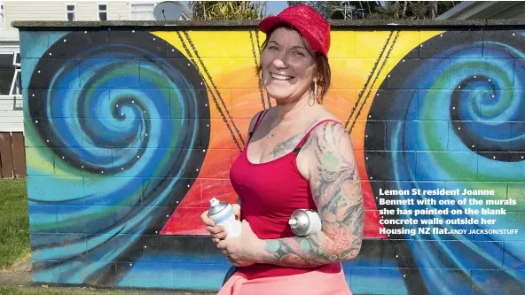  ?? ANDY JACKSON/STUFF ?? Lemon St resident Joanne Bennett with one of the murals she has painted on the blank concrete walls outside her Housing NZ flat.