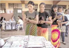  ?? — AFP ?? Indigenous women of the Maka tribe prepare to vote at a polling station in Mariano Roque Alonso, outskirts of Asuncion on Sunday.