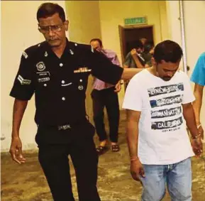  ?? PIC BY SYARAFIQ ABD SAMAD ?? M. Gunasegara­n being led out of the magistrate’s court in Petaling Jaya yesterday.