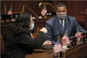  ?? AP PHOTO/JESSICA HILL ?? State Rep. Hilda Santiago, D-Meriden, left, talks with Rep. Larry Butler, D-Waterbury, right, during session at the State Capitol in Hartford, Conn., on April 19.