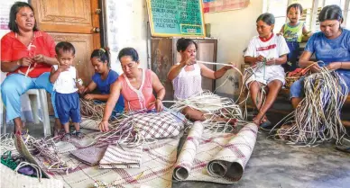  ??  ?? BOLINAO WEAVERS — Women of all ages in Barangay Salud, Santiago Island in Bolinao are busy with their hands at the barangay center which serves as a work area for ‘buri’ mat weavers. (Jojo Riñoza)