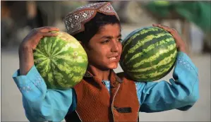  ?? Picture: Noorullah Shirzada/afp ?? „ An Afghan street vendor holds watermelon­s as he waits for customers before the iftar meal at sunset. During Ramadan, many Muslims fast from dawn to dusk.