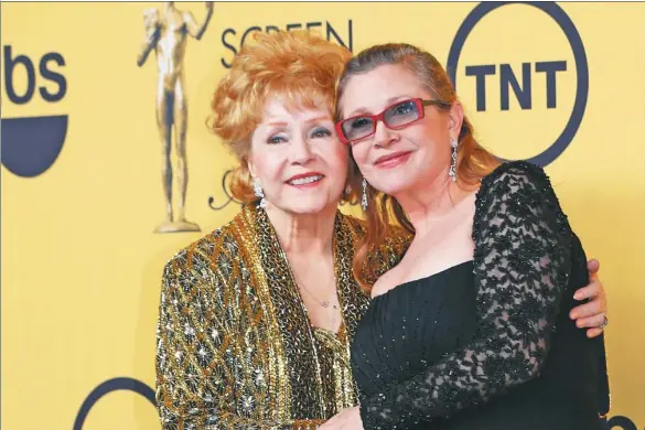  ?? MIKE BLAKE / REUTERS ?? Debbie Reynolds poses with her daughter Carrie Fisher backstage after accepting her Lifetime Achievemen­t award at the 21st annual Screen Actors Guild Awards.