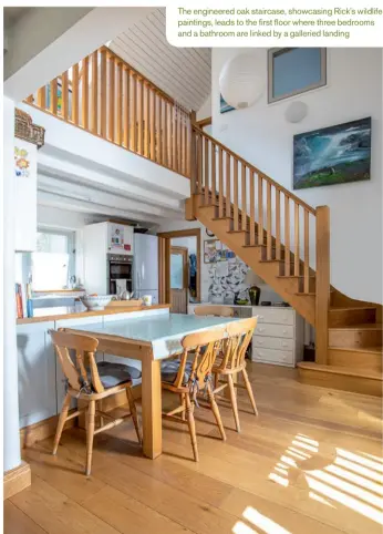  ??  ?? The engineered oak staircase, showcasing Rick’s wildlife paintings, leads to the first floor where three bedrooms and a bathroom are linked by a galleried landing