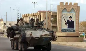  ?? ?? Marines in a light armoured vehicle pass a Saddam Hussein portrait in the centre of Tikrit in 2003. Photograph: Marco Di Lauro/Getty Images