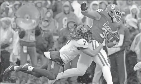  ?? Alonzo Adams / The Associated Press ?? Oklahoma’s Dimitri Flowers (right) tries to get by Oklahoma State’s Ramon Richards during the first half of Saturday’s game in Norman, Okla.