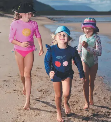  ?? Picture: STEWART McLEAN ?? SMART: Poppy Ray, 7, Neeka Ray, 4, and Anise Van Gemert, 7, keep safe while enjoying the tropical sunshine on the Cairns Esplanade.